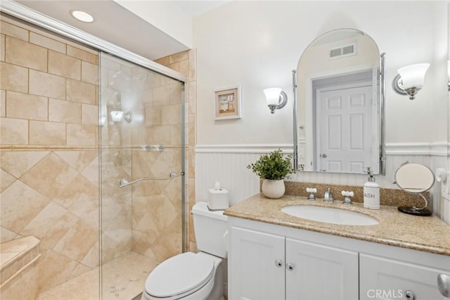 bathroom with an enclosed shower, vanity, and toilet