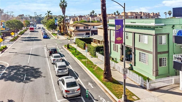 view of road with street lights, curbs, sidewalks, and a residential view