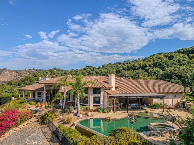 back of property featuring a pool with hot tub and a patio area