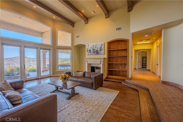 living room featuring a towering ceiling, beam ceiling, and a mountain view