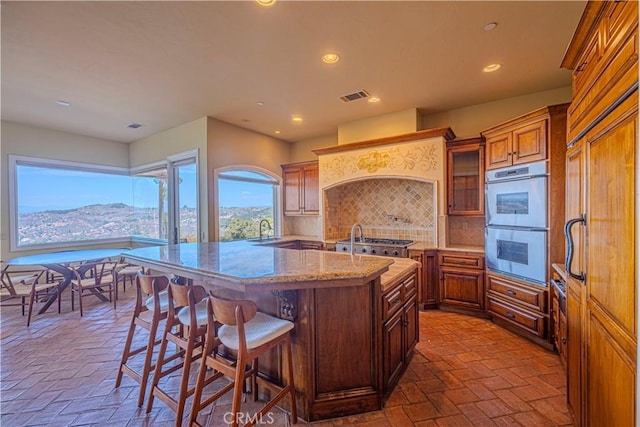 kitchen featuring sink, a breakfast bar, backsplash, stainless steel appliances, and a mountain view