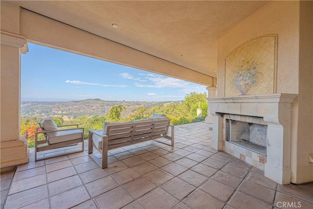 view of patio featuring an outdoor living space with a fireplace and a mountain view