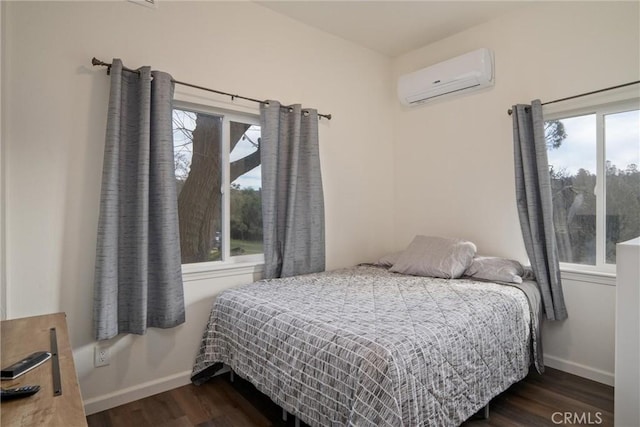 bedroom with a wall unit AC and dark hardwood / wood-style floors