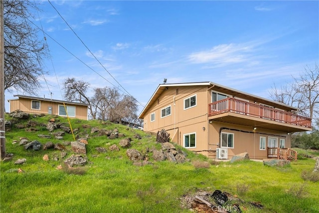 rear view of house featuring a deck and a lawn