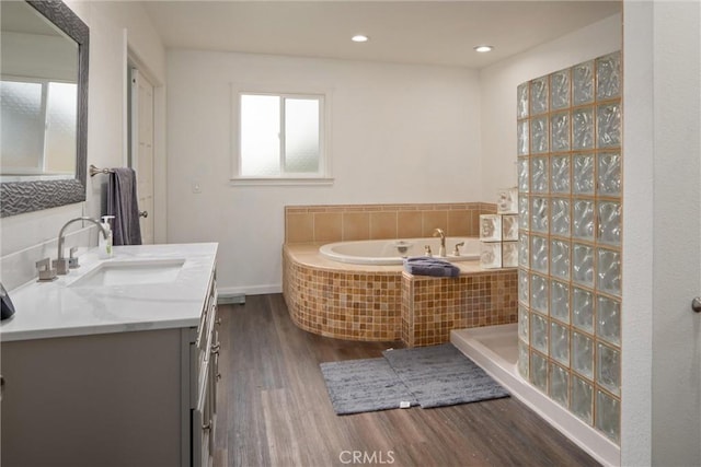 bathroom featuring hardwood / wood-style flooring, vanity, and walk in shower