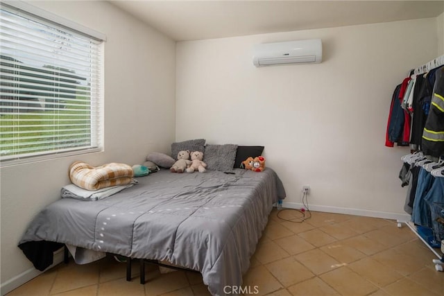 bedroom featuring a wall unit AC and light tile patterned flooring