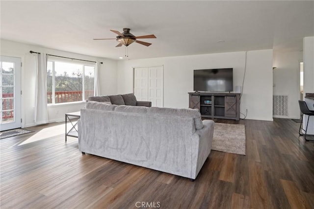 living room with dark hardwood / wood-style floors and ceiling fan