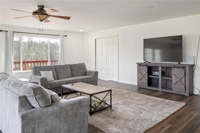 living room with ceiling fan and dark hardwood / wood-style flooring