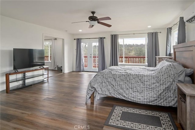 bedroom with french doors, a wall mounted AC, dark hardwood / wood-style floors, ceiling fan, and access to exterior