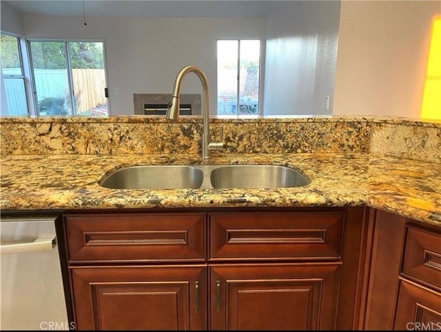 details featuring light stone counters, sink, and stainless steel dishwasher