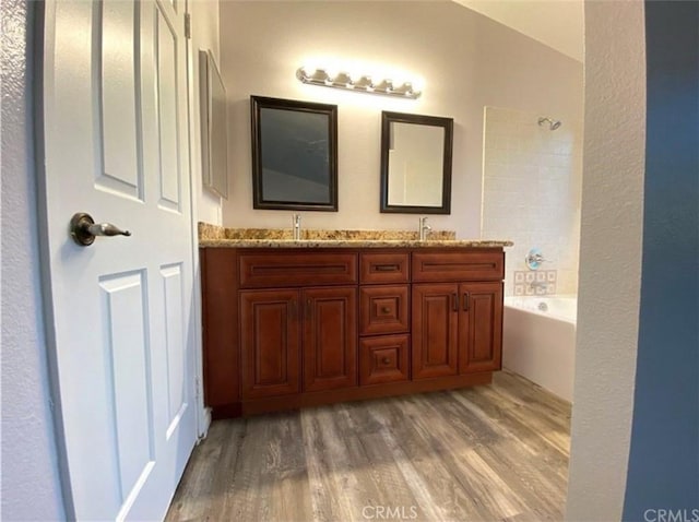 bathroom with shower / bath combination, wood-type flooring, and vanity