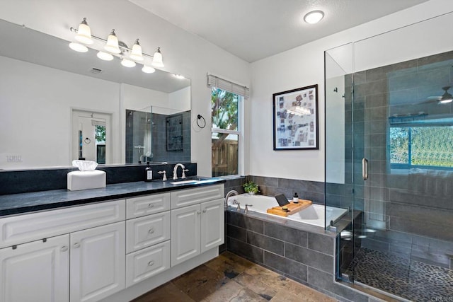 bathroom with ceiling fan, vanity, and shower with separate bathtub