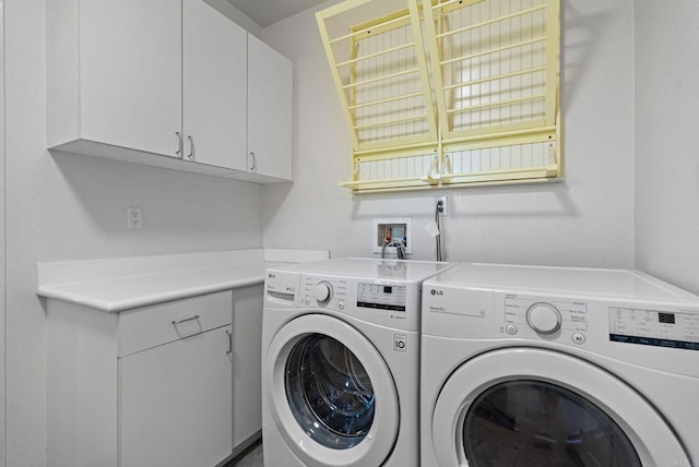 clothes washing area featuring cabinets and separate washer and dryer