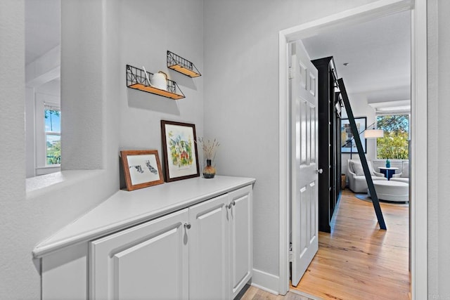 corridor with light hardwood / wood-style floors