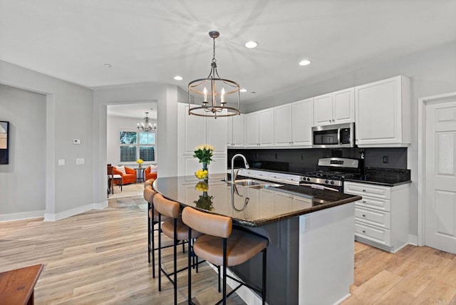 kitchen featuring white cabinetry, sink, a center island with sink, and appliances with stainless steel finishes