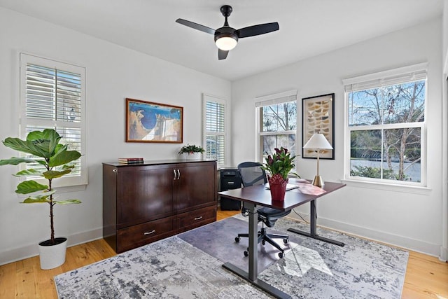 home office with ceiling fan and light hardwood / wood-style floors