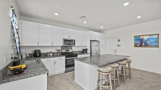 13180 Mesa Ln, Yucaipa, CA 92399 - kitchen featuring stainless steel appliances, a sink, a kitchen breakfast bar, a kitchen island, and white cabinets