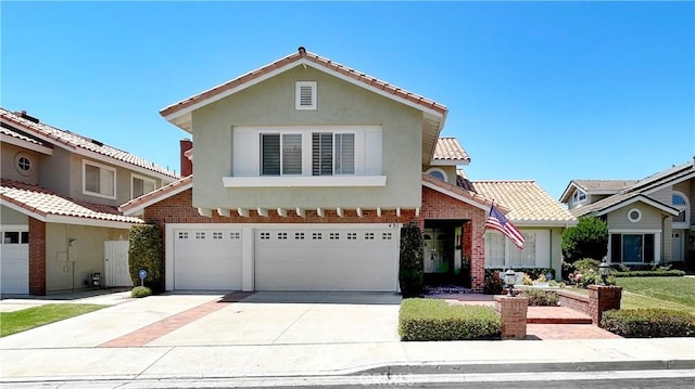 view of front facade featuring stucco siding, a tiled roof, driveway, and a garage