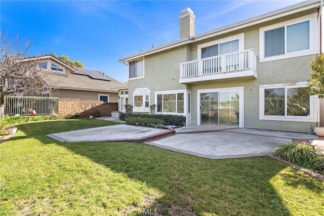 rear view of house featuring a patio area, stucco siding, a lawn, and fence