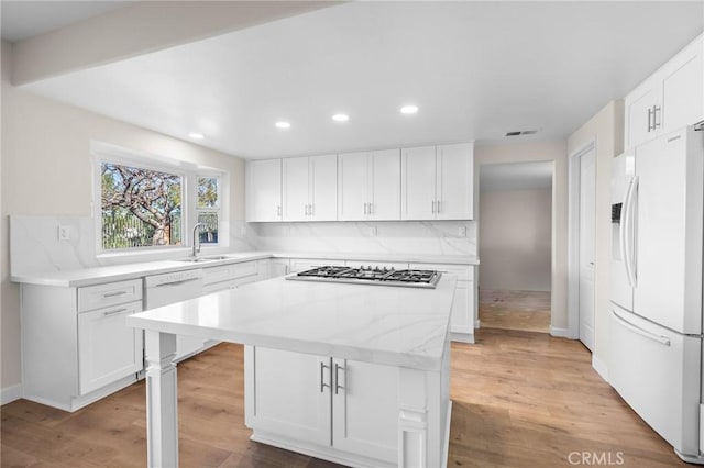 kitchen featuring white appliances, light wood-style floors, and backsplash