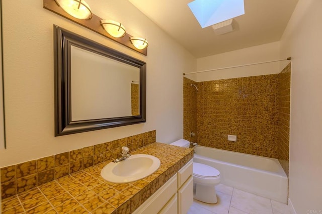 full bathroom with tile patterned flooring, a skylight, vanity, toilet, and tiled shower / bath