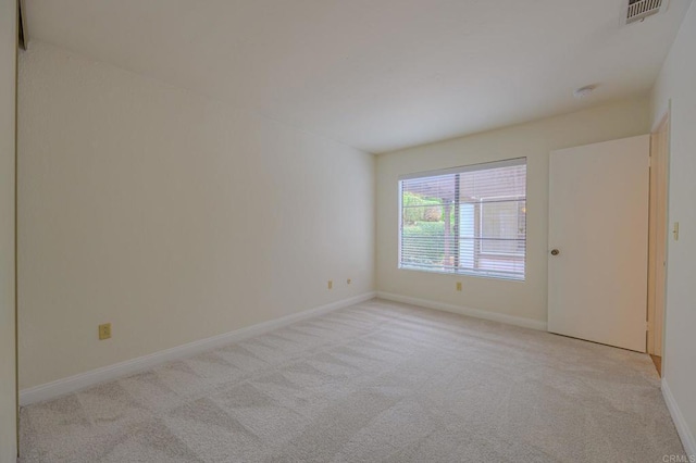 spare room featuring light carpet