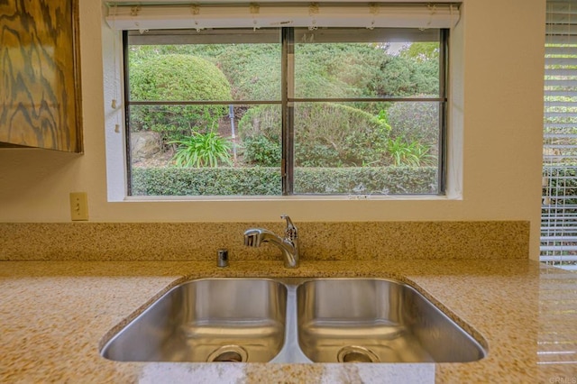 interior space featuring light stone countertops and sink