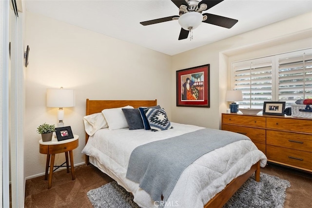 bedroom with ceiling fan, dark carpet, and baseboards