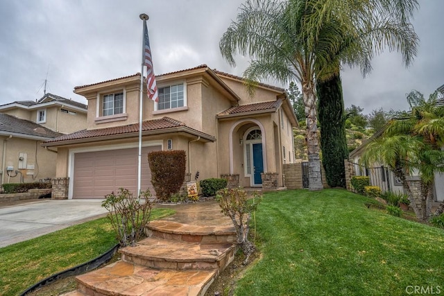 mediterranean / spanish-style house with a garage, concrete driveway, a front lawn, and stucco siding