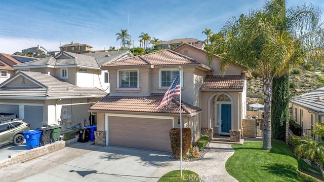 mediterranean / spanish home featuring driveway, a tiled roof, an attached garage, and stucco siding