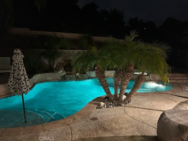 pool at night featuring an outdoor pool