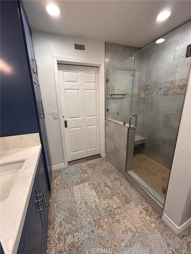 bathroom with vanity and a shower with shower door