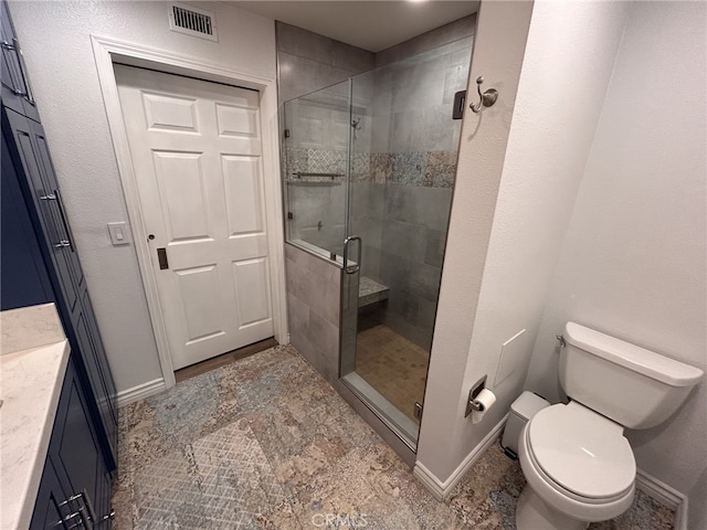 bathroom with walk in shower, vanity, and toilet