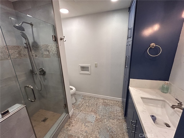 bathroom with vanity, a shower with door, and toilet