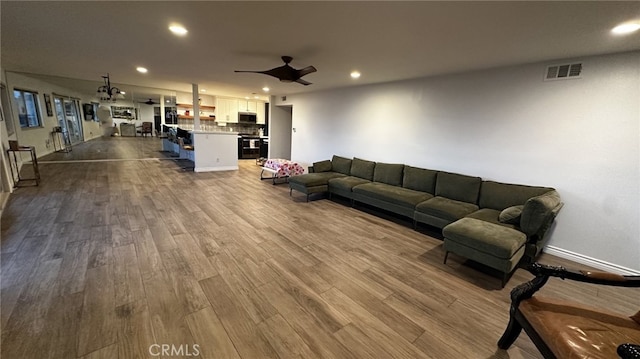 living room featuring ceiling fan and hardwood / wood-style floors