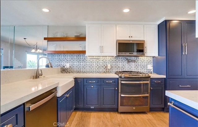 kitchen featuring white cabinetry, stainless steel appliances, sink, and light hardwood / wood-style flooring