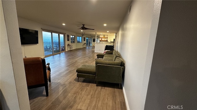 living room featuring recessed lighting, wood finished floors, a ceiling fan, and baseboards