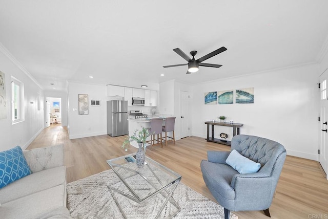 living room with crown molding, ceiling fan, and light hardwood / wood-style flooring