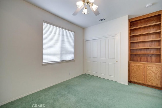 unfurnished bedroom featuring light carpet, a closet, and ceiling fan