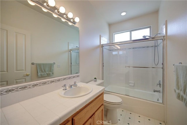 full bathroom featuring toilet, shower / bath combination with glass door, and vanity