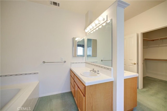 bathroom with vanity and tiled tub