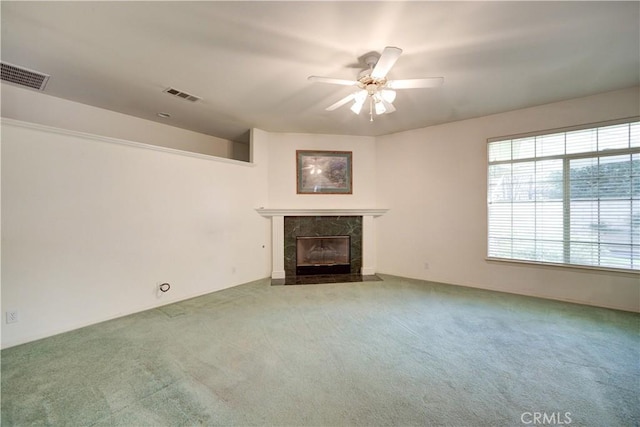 unfurnished living room featuring a fireplace, carpet floors, and ceiling fan