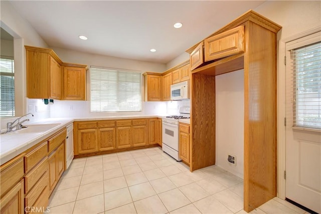 kitchen featuring white appliances, light tile patterned floors, and sink