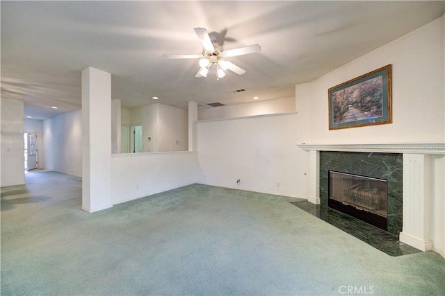 unfurnished living room featuring ceiling fan, dark colored carpet, and a fireplace