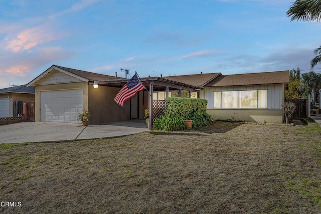 ranch-style home with a garage, a yard, and a pergola