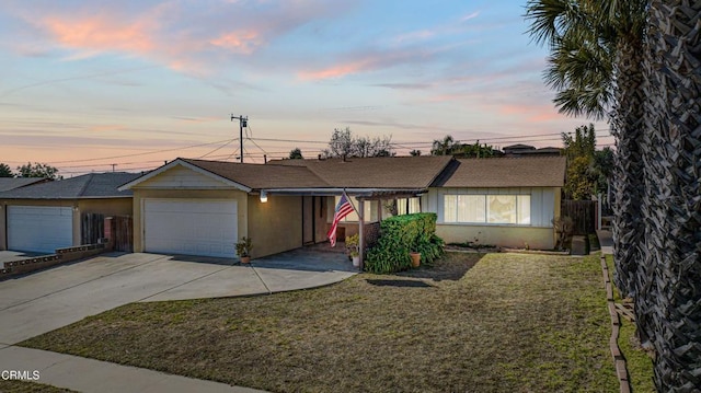 ranch-style home featuring a yard and a garage