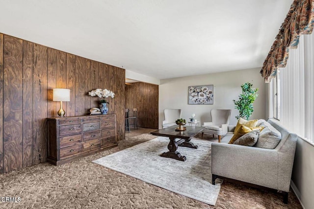 living room featuring carpet and wood walls