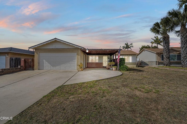 ranch-style home featuring a garage, a yard, and a carport