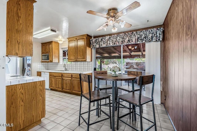 kitchen featuring white appliances, plenty of natural light, tile countertops, and sink