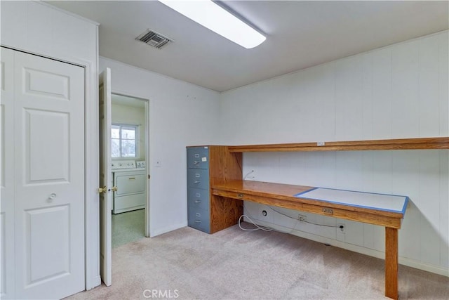 unfurnished office featuring washer and clothes dryer and light colored carpet